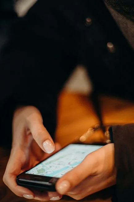 Detailed close-up of a smartphone with a stylus resting on a vivid red surface, highlighting contemporary technology.